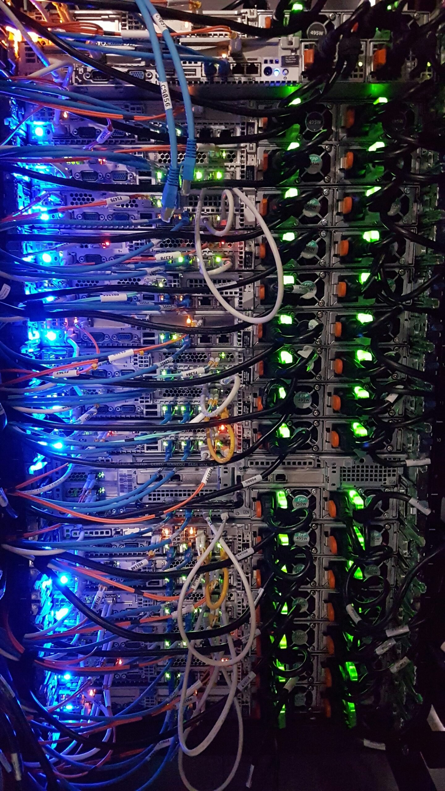 Close-up view of a server rack filled with colorful network cables and illuminated hardware lights in a data center.
