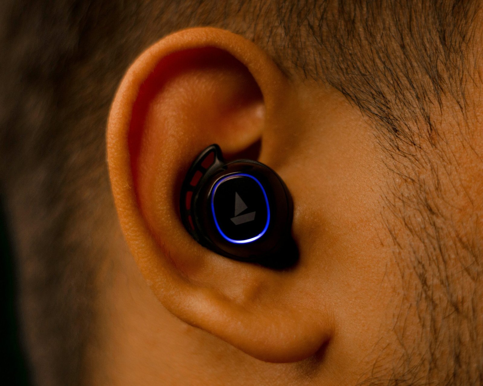 Close up view of a wireless earbud placed inside a person’s ear showing the design of new earable devices.