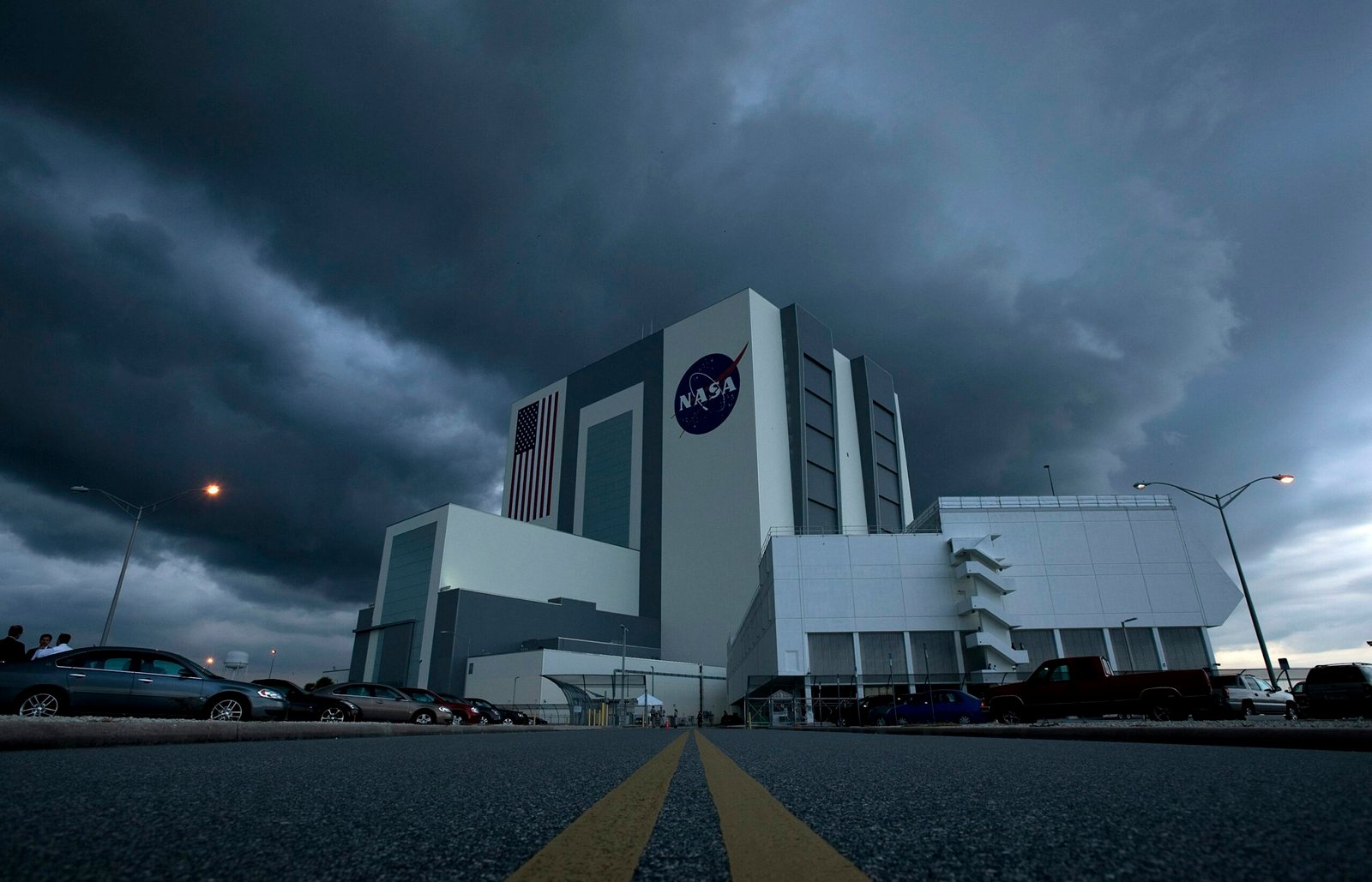 NASA Kennedy Space Center stands under dark storm clouds as the agency prepares for new lunar mission decisions.