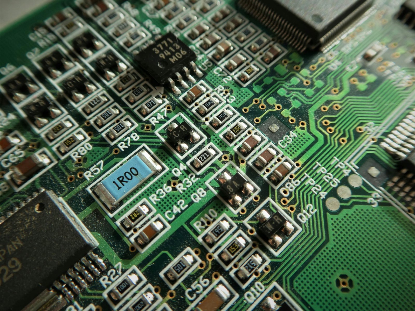 "Close-up of semiconductor components on a green circuit board"